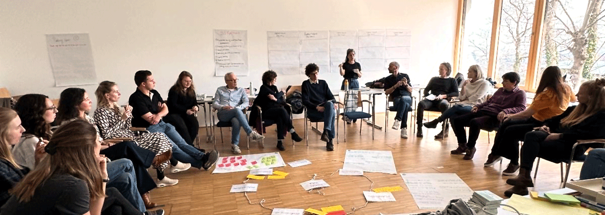 Seminar oder Workshop mit vielen Teilnehmern, die in einem Halbkreis sitzen.