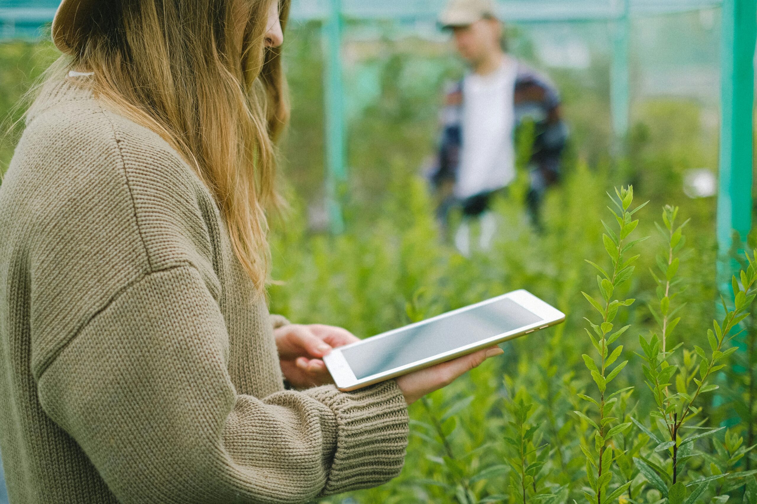Frau mit Tablet im Gewächshaus